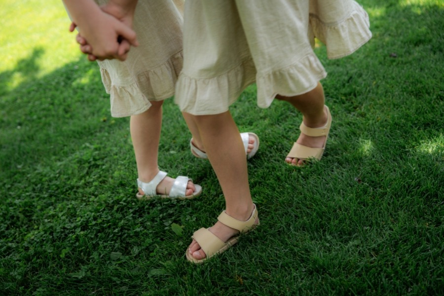 Kids' barefoot sandals worn on the grass Kids' barefoot sandals worn on the grass