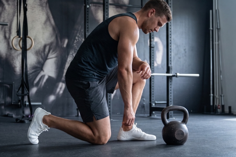 Lacing men's barefoot training shoes before a workout